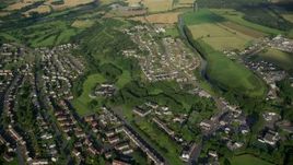 5.5K aerial stock footage fly over village homes and farm fields by a river, Bonnybridge, Scotland Aerial Stock Footage | AX111_004E