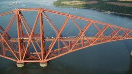 5.5K aerial stock footage of approaching a commuter train on Forth Bridge in Scotland Aerial Stock Footage | AX111_080E