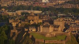 5.5K aerial stock footage of flying by the hilltop Edinburgh Castle, Scotland at sunset Aerial Stock Footage | AX112_034E