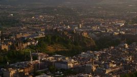 5.5K aerial stock footage of Edinburgh Castle on a hilltop in Scotland at sunset Aerial Stock Footage | AX112_042E
