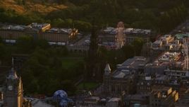 5.5K aerial stock footage of a view of Scott Monument and ferris wheel, Edinburgh, Scotland at sunset Aerial Stock Footage | AX112_044E
