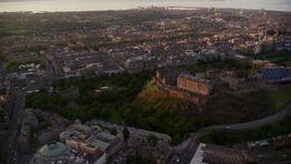 5.5K aerial stock footage of flying by cityscape and Edinburgh Castle, Scotland at sunset Aerial Stock Footage | AX112_084E
