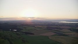 5.5K aerial stock footage pan across farming fields at sunset in Linlithgow, Scotland Aerial Stock Footage | AX112_133E
