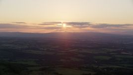 5.5K aerial stock footage of the setting sun over farmland in Linlithgow, Scotland Aerial Stock Footage | AX112_137