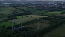 5.5K aerial stock footage of orbiting radio towers surrounded by farmland, Falkirk, Scotland at twilight Aerial Stock Footage | AX112_151
