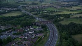 5.5K aerial stock footage of orbiting M80 Highway near rural homes, Cumbernauld, Scotland at twilight Aerial Stock Footage | AX112_160