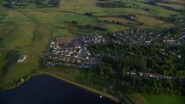 5.5K aerial stock footage of orbiting homes in the village of Eaglesham, Scotland at sunrise Aerial Stock Footage | AX113_009