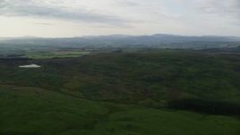 5.5K aerial stock footage of flying by hilly moorland, reveal farms, Maybole, Scotland Aerial Stock Footage | AX113_051E