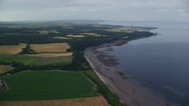 5.5K aerial stock footage fly over farm fields and beach along Firth of Clyde, Maybole, Scotland Aerial Stock Footage | AX113_053