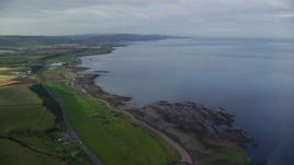 5.5K aerial stock footage of coastline and farming fields along Firth of Clyde, Girvan, Scotland Aerial Stock Footage | AX113_063E