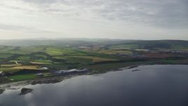 5.5K aerial stock footage of passing the coastline and farms along Firth of Clyde, Girvan, Scotland Aerial Stock Footage | AX113_066