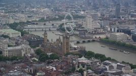 5.5K aerial stock footage of Big Ben, Parliament, and London Eye beside the River Thames, England Aerial Stock Footage | AX114_175E