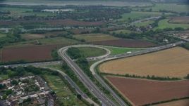 5.5K aerial stock footage of orbiting M4 Freeway Interchange by farmland, Windsor England Aerial Stock Footage | AX114_324E