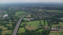 5.5K aerial stock footage approach M25 Freeway from neighborhoods, Chertsey, England Aerial Stock Footage | AX114_352E