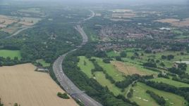 5.5K aerial stock footage of orbiting freeway through trees, Redhill, England Aerial Stock Footage | AX114_379E