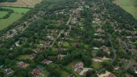 5.5K aerial stock footage of flying over residential community and trees, Redhill, England Aerial Stock Footage | AX114_387