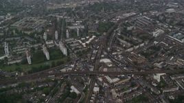 5.5K aerial stock footage fly over residential area with train tracks in the rain, London, England Aerial Stock Footage | AX115_056