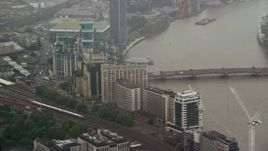 5.5K aerial stock footage of MI6 Building and Vauxhall Bridge over the River Thames in the rain, London, England Aerial Stock Footage | AX115_061