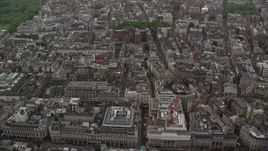 5.5K aerial stock footage tilt from office buildings in the rain to wider view of the city, London, England Aerial Stock Footage | AX115_077
