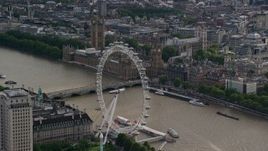5.5K aerial stock footage approach the London Eye beside the River Thames, near Parliament, England Aerial Stock Footage | AX115_196