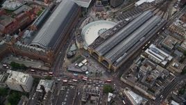 5.5K aerial stock footage of tilting to bird's eye of Kings Cross Train Station, London, England Aerial Stock Footage | AX115_238