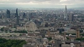 5.5K aerial stock footage of the London Eye with skyscrapers in the background, England Aerial Stock Footage | AX115_266