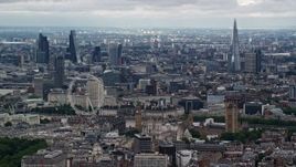 5.5K aerial stock footage of the London Eye with skyscrapers in the background, England Aerial Stock Footage | AX115_266E