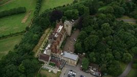 5.5K aerial stock footage of Nutfield Priory Hotel with trees, Redhill, England Aerial Stock Footage | AX115_315E