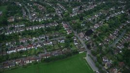 5.5K aerial stock footage of flying away from homes, revealing sports fields and warehouse buildings, Purley, England, twilight Aerial Stock Footage | AX116_004E