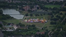 5.5K aerial stock footage of flying by small fair at Burgess Park, London, England, twilight Aerial Stock Footage | AX116_007