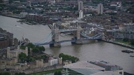 5.5K aerial stock footage of flying by Tower Bridge spanning the River Thames in London, England, twilight Aerial Stock Footage | AX116_020