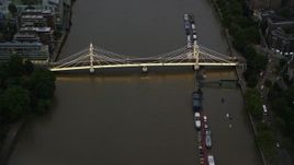 5.5K aerial stock footage of approaching Albert Bridge spanning the River Thames, London, England, night Aerial Stock Footage | AX116_120E