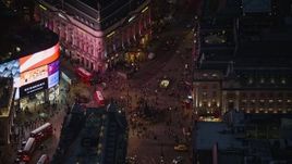 5.5K aerial stock footage flying by crowds and double decker buses at Piccadilly Circus, London, England, night Aerial Stock Footage | AX116_182E