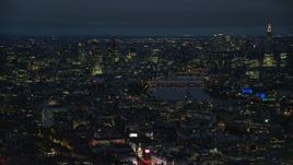 5.5K aerial stock footage of passing cityscape, London Eye and Big Ben by River Thames, London, England, night Aerial Stock Footage | AX116_190E