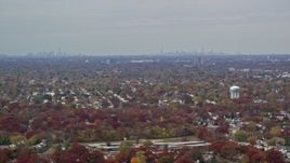 5.5K aerial stock footage of a suburban neighborhood and NYC skyline in Autumn, Farmingdale, New York Aerial Stock Footage | AX117_003