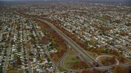 5.5K aerial stock footage of suburbs and freeway with light traffic in Autumn, Massapequa, New York Aerial Stock Footage | AX117_008E