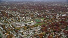 5.5K aerial stock footage of a high school in the suburbs in Autumn, Merrick, New York Aerial Stock Footage | AX117_030E