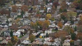 5.5K aerial stock footage of passing and flying away from suburban homes in Autumn, Bellmore, New York Aerial Stock Footage | AX117_042E