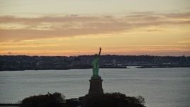 5.5K aerial stock footage of flying by the Statue of Liberty at sunrise, New York Aerial Stock Footage | AX118_040E