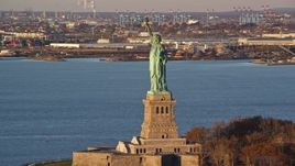 5.5K aerial stock footage of flying by the Statue of Liberty at sunrise in New York Aerial Stock Footage | AX118_103