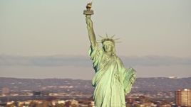 5.5K aerial stock footage of orbiting the iconic Statue of Liberty monument at sunrise in New York Aerial Stock Footage | AX118_105E