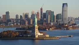 5.5K aerial stock footage of orbiting the front of the Statue of Liberty monument at sunrise in New York Aerial Stock Footage | AX118_124E