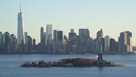 5.5K aerial stock footage of Statue of Liberty and Lower Manhattan skyline at sunrise in New York Aerial Stock Footage | AX118_129E