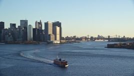 5.5K aerial stock footage orbit Staten Island Ferry near Lower Manhattan skyline at sunrise in New York City Aerial Stock Footage | AX118_135