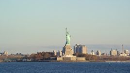 5.5K aerial stock footage low altitude view of Statue of Liberty at sunrise in New York Aerial Stock Footage | AX118_140E