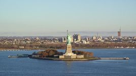 5.5K aerial stock footage of an approach to the Statue of Liberty at sunrise in New York Aerial Stock Footage | AX118_142E