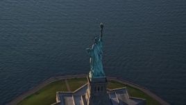 5.5K aerial stock footage of flying away from the Statue of Liberty at sunrise in New York Aerial Stock Footage | AX118_148