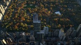 5.5K aerial stock footage approach One57 skyscraper and Central Park with Autumn leaves at sunrise in New York City Aerial Stock Footage | AX118_189
