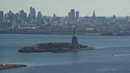 5.5K aerial stock footage of the Statue of Liberty in Autumn, Brooklyn in the background, New York Aerial Stock Footage | AX119_009E