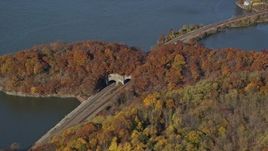 5.5K aerial stock footage orbit riverfront railroad tracks and tunnel in Autumn, Croton on Hudson, New York Aerial Stock Footage | AX119_136